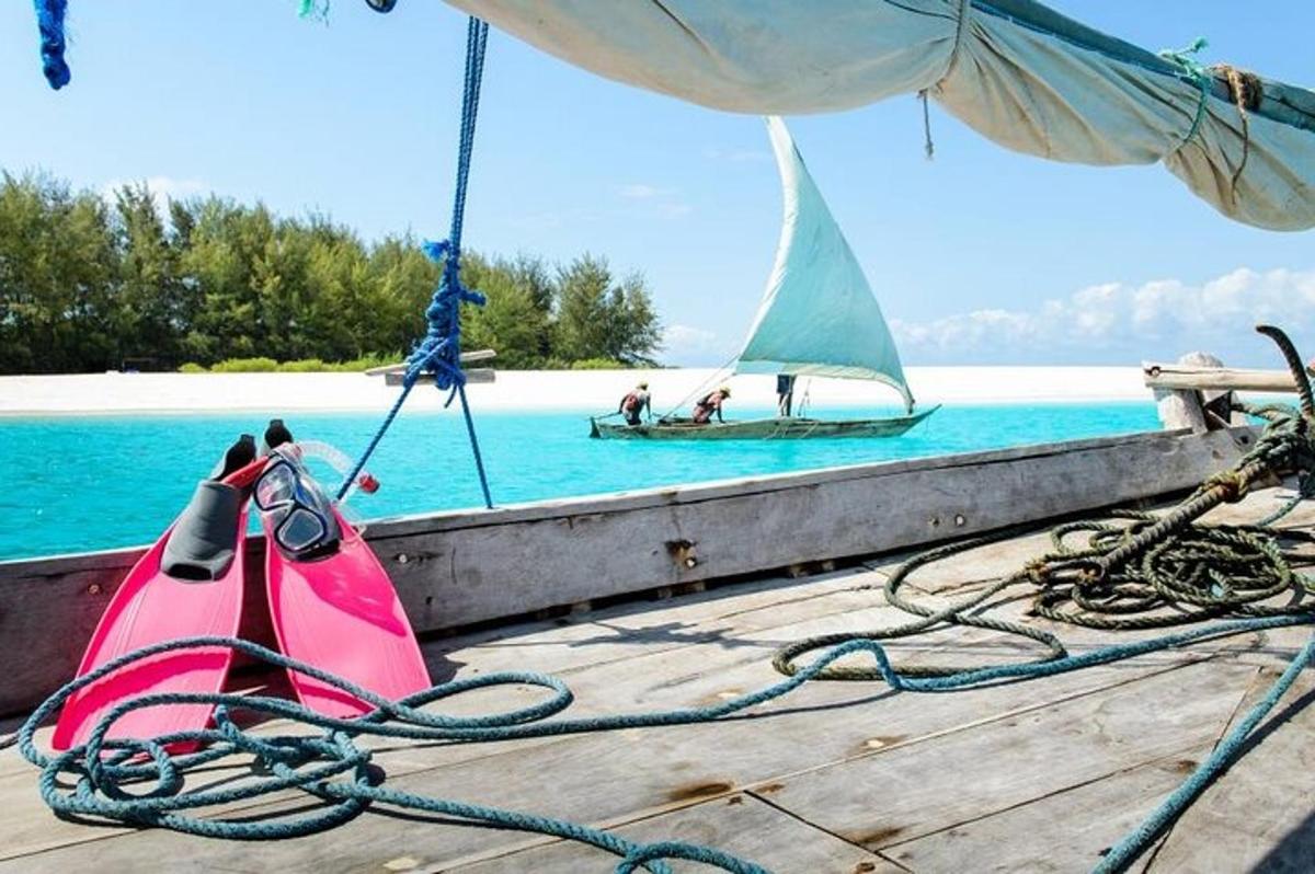 un molo con due kayak rosa e una barca a vela in acqua