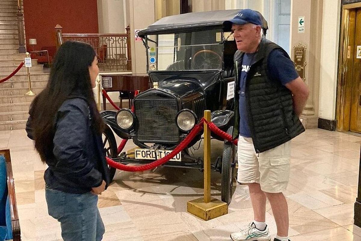 muž a žena si prohlížejí staré auto