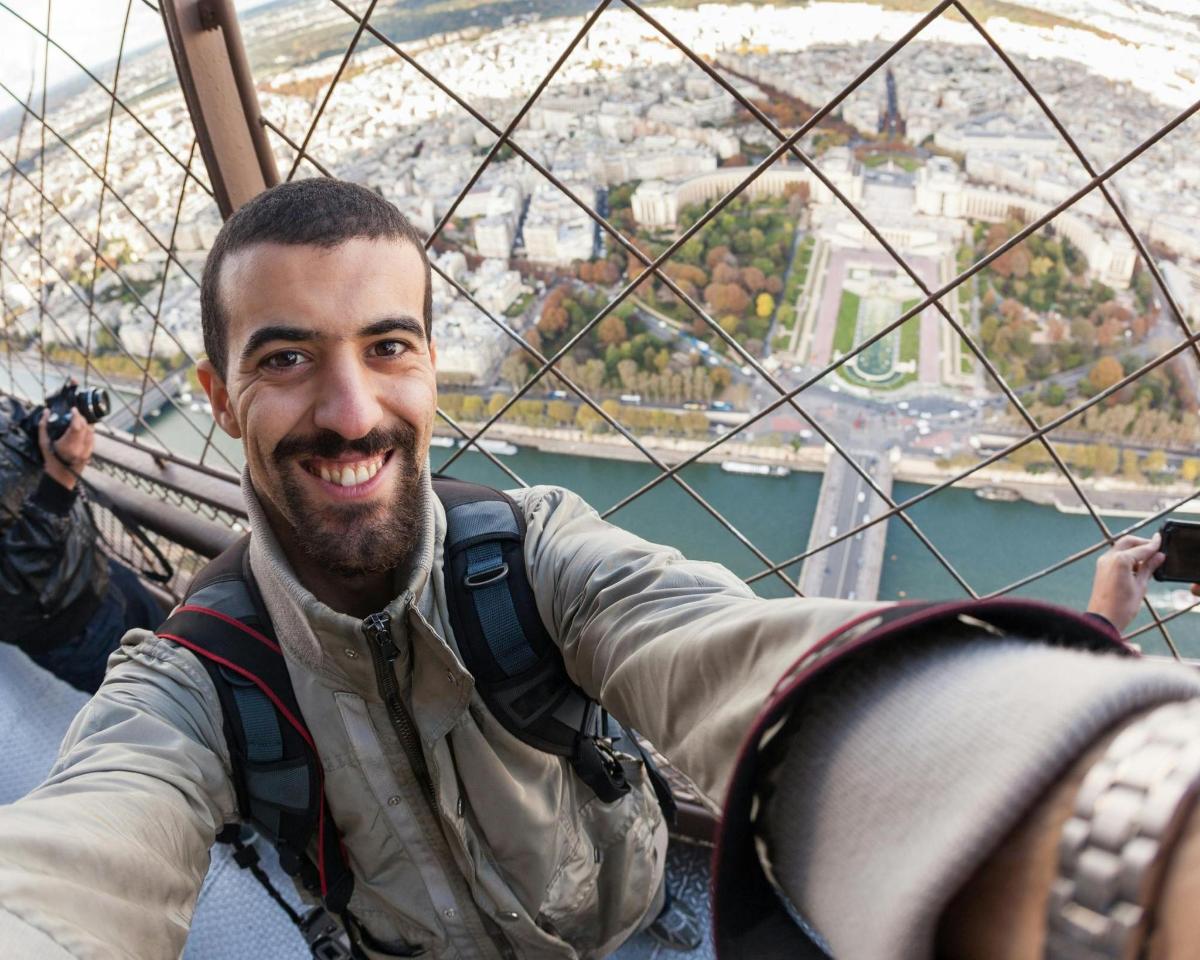un uomo sorride mentre è su una ruota panoramica