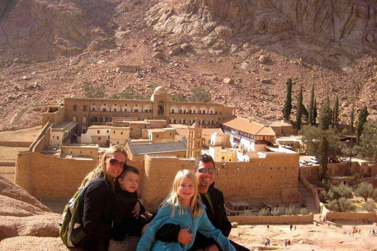 مجموعة من الأشخاص يجلسون على صخرة أمام قرية