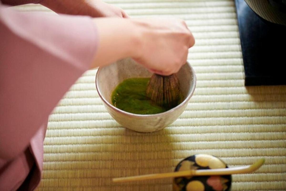 a person holding a brush in a bowl of green liquid