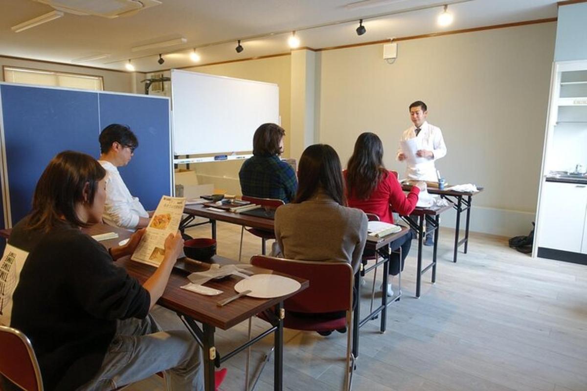 Un grupo de personas sentadas en mesas en un aula.