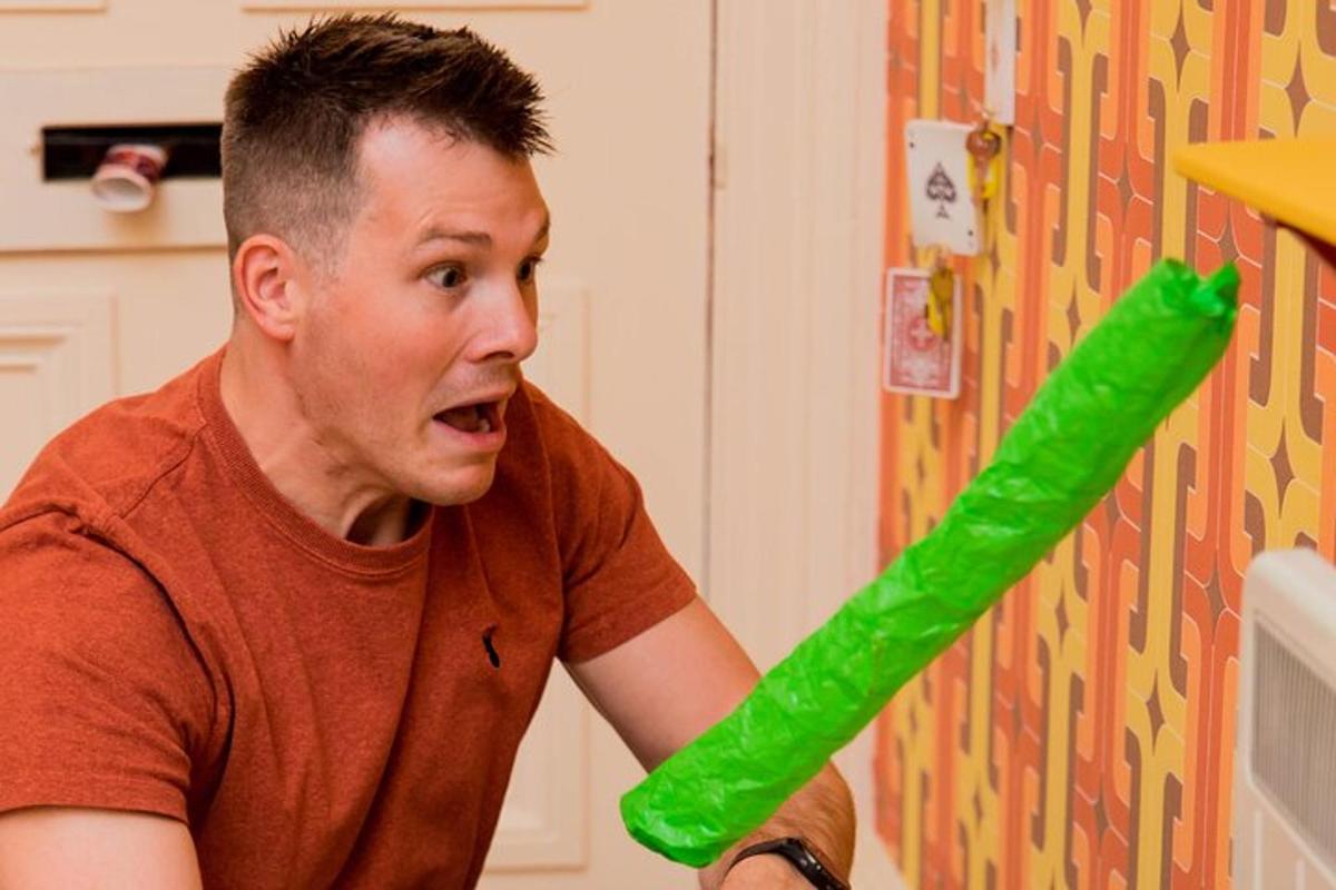 um homem está segurando um tubo de plástico verde