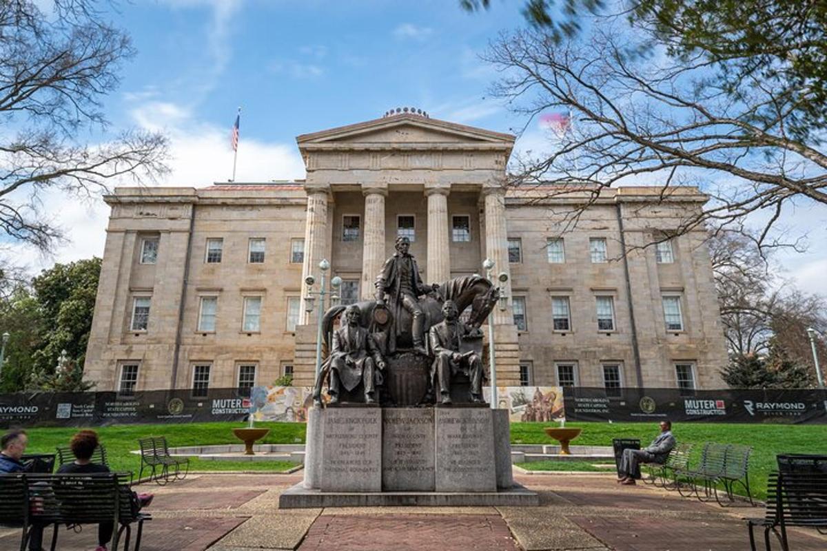 a statue in front of a building with people sitting on benches