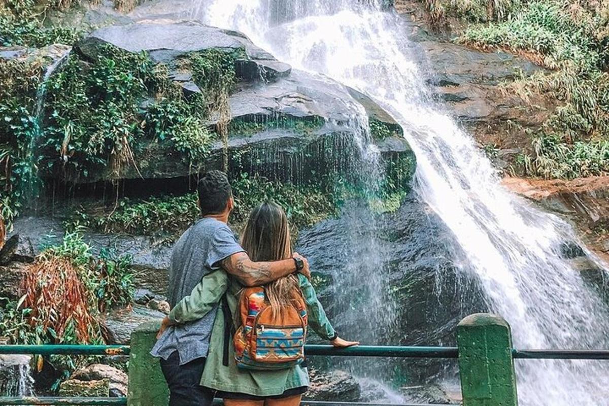 pasangan yang berdiri di hadapan air terjun
