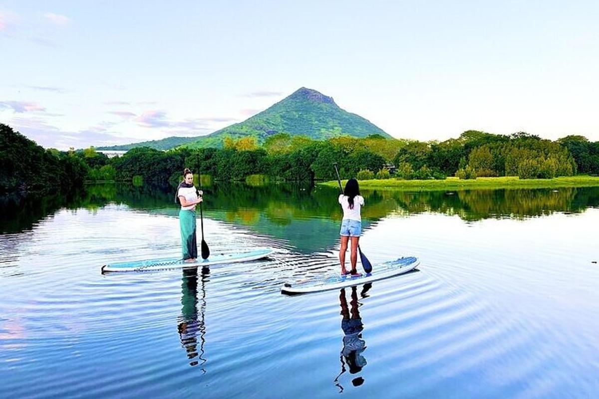 dva lidé stojí na paddleboardech ve vodě