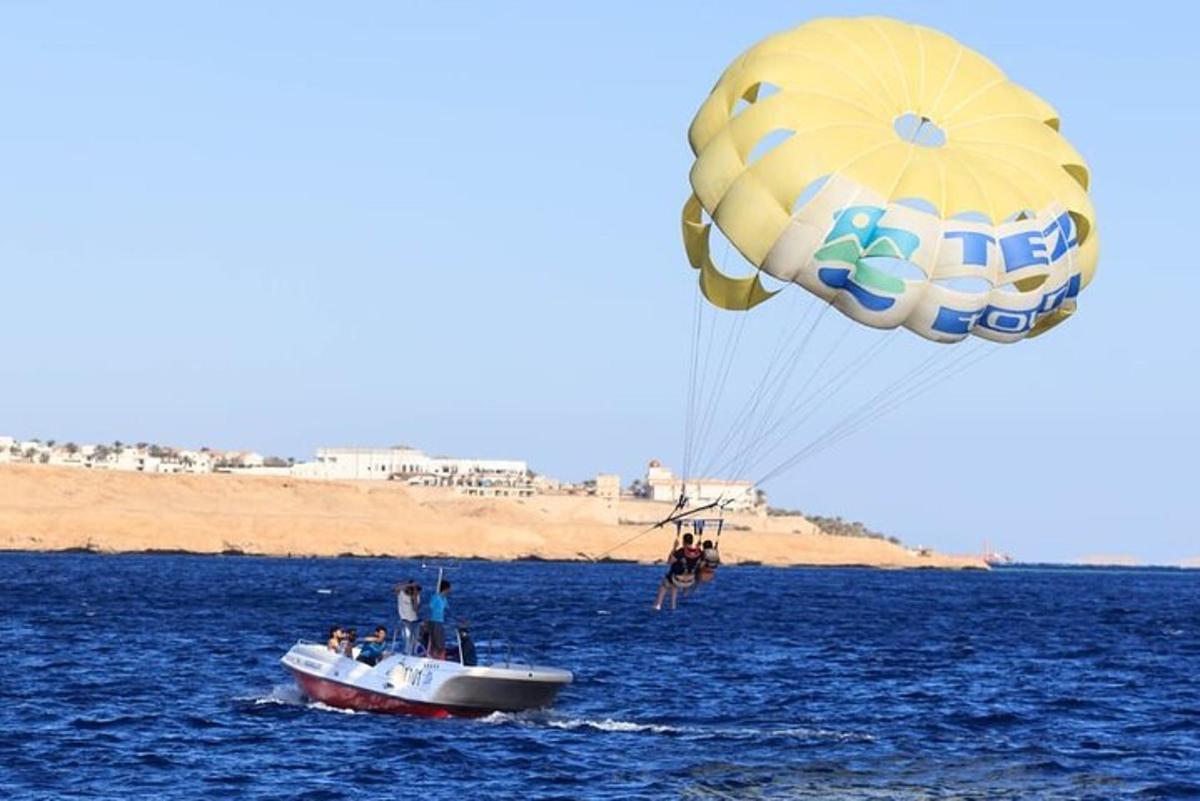 un gran paracaigudes volant sobre un vaixell a l'aigua