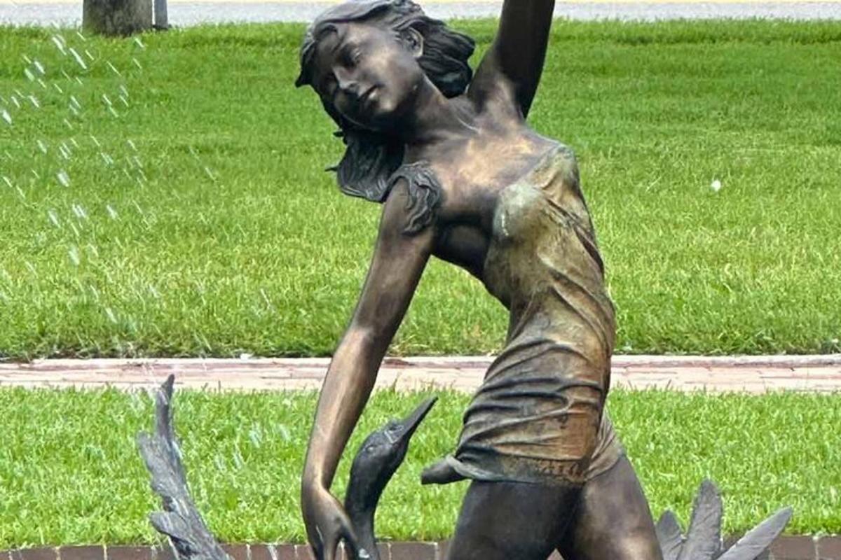 статуя дівчини з рукою в повітрі