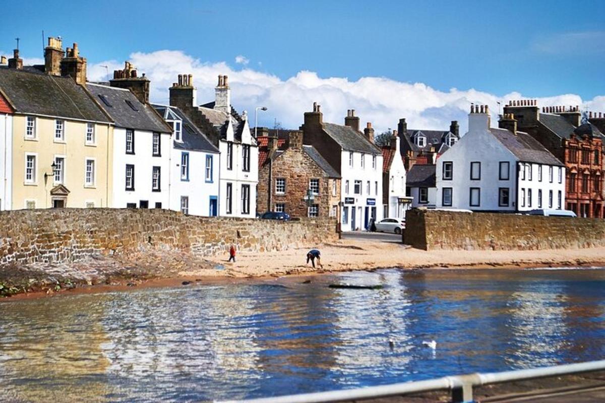 a group of houses on a beach next to the water