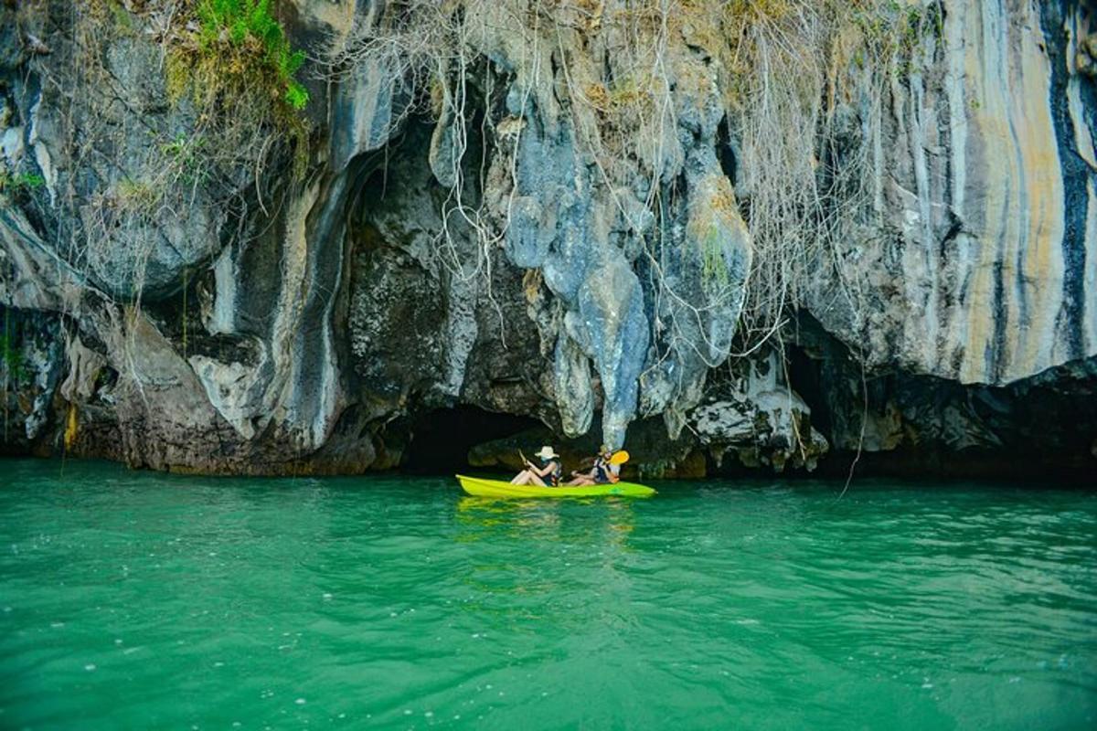 two people in a kayak in front of a cave