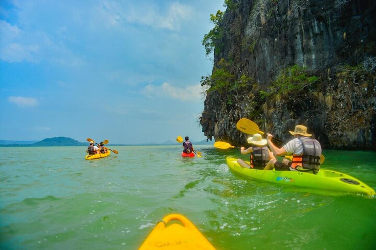 a group of people kayaking in the water near a mountain