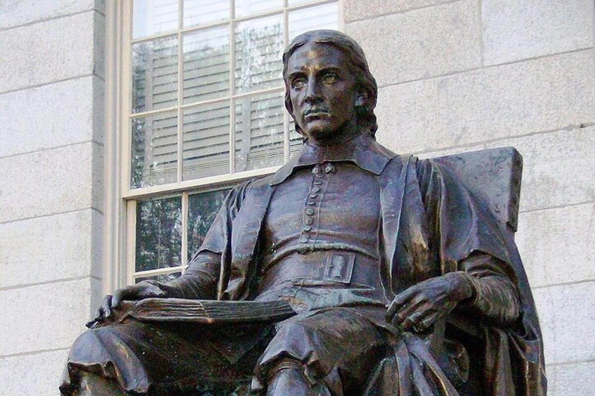 una estatua de un hombre sentado frente a un edificio