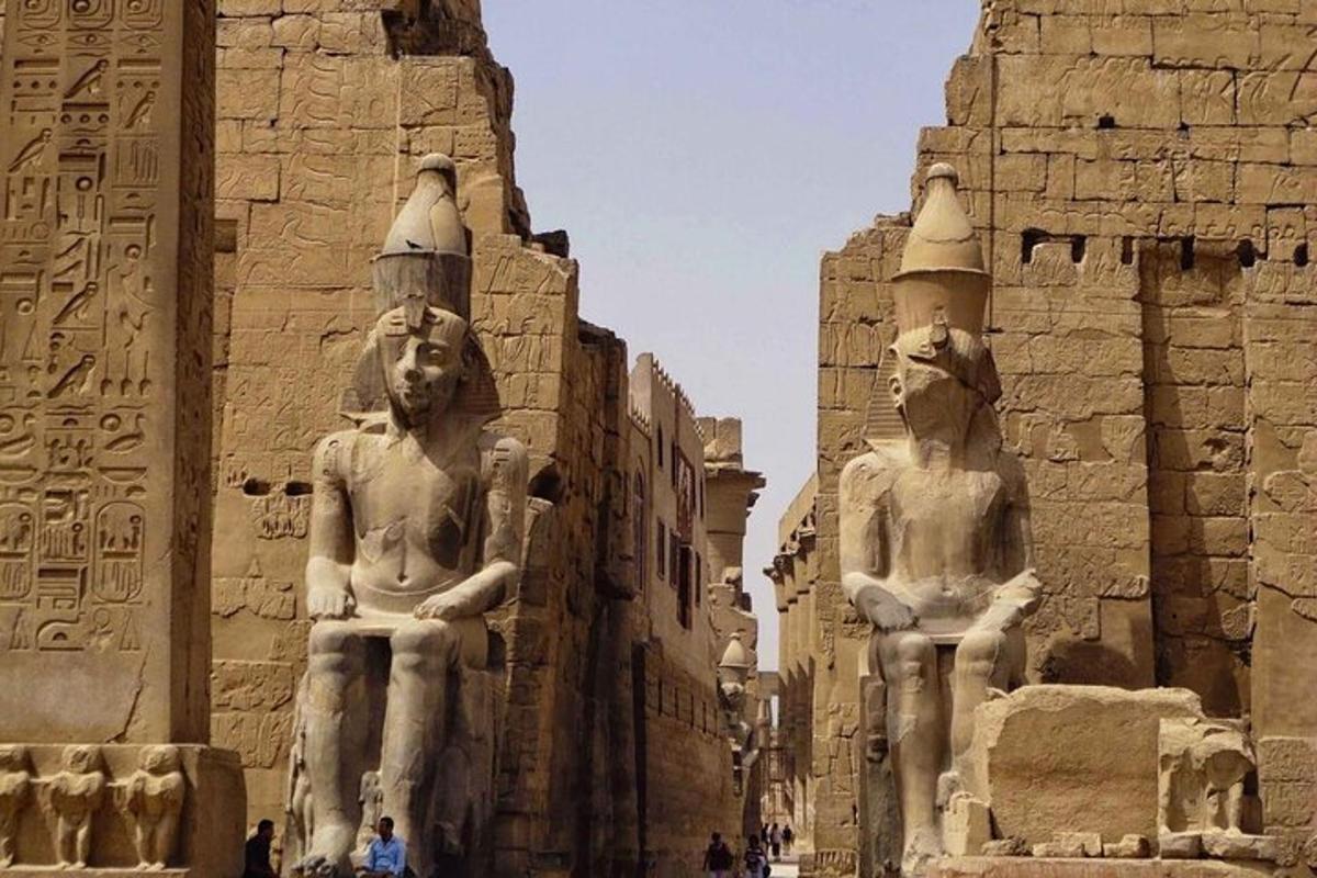 due statue di persone in piedi davanti a un edificio