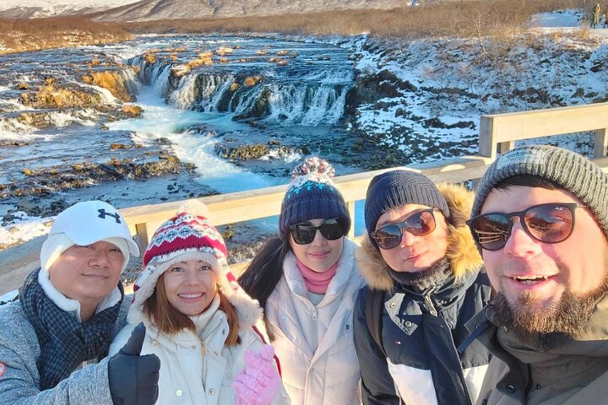 un gruppo di persone in piedi davanti a una cascata