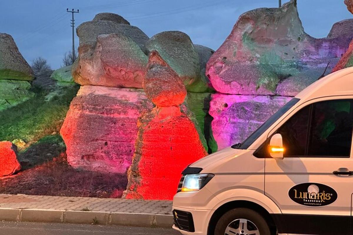 a van parked in front of a mural of rocks