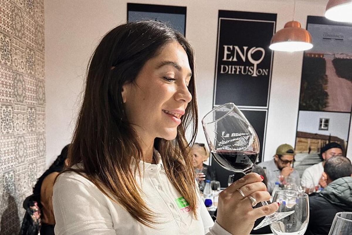 uma mulher está segurando uma taça de vinho