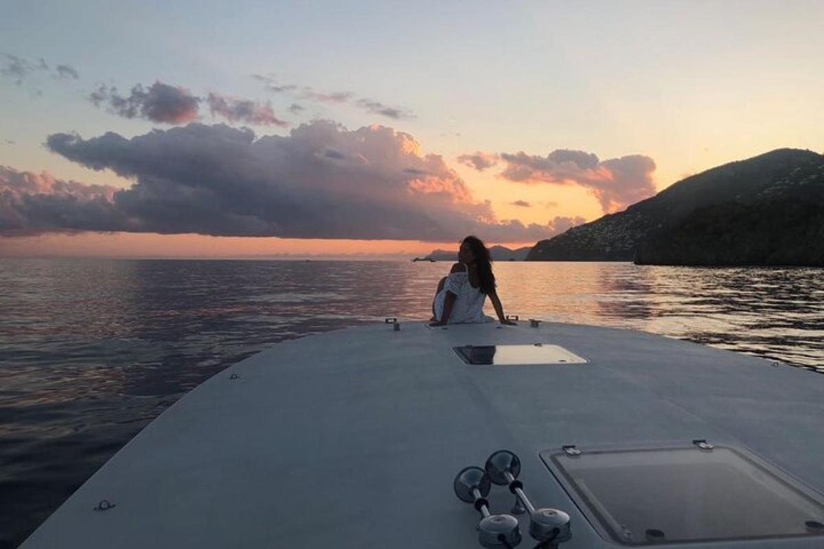 a person sitting on the front of a boat in the water