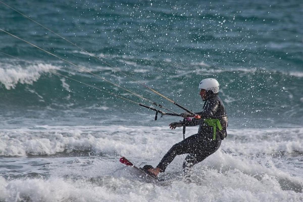 a man in the ocean holding onto a kite
