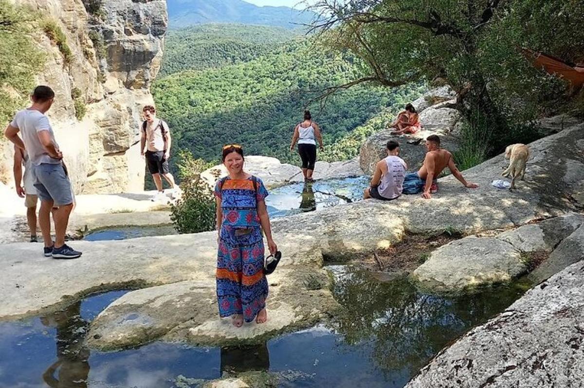 seorang wanita berdiri di atas batu di kolam air