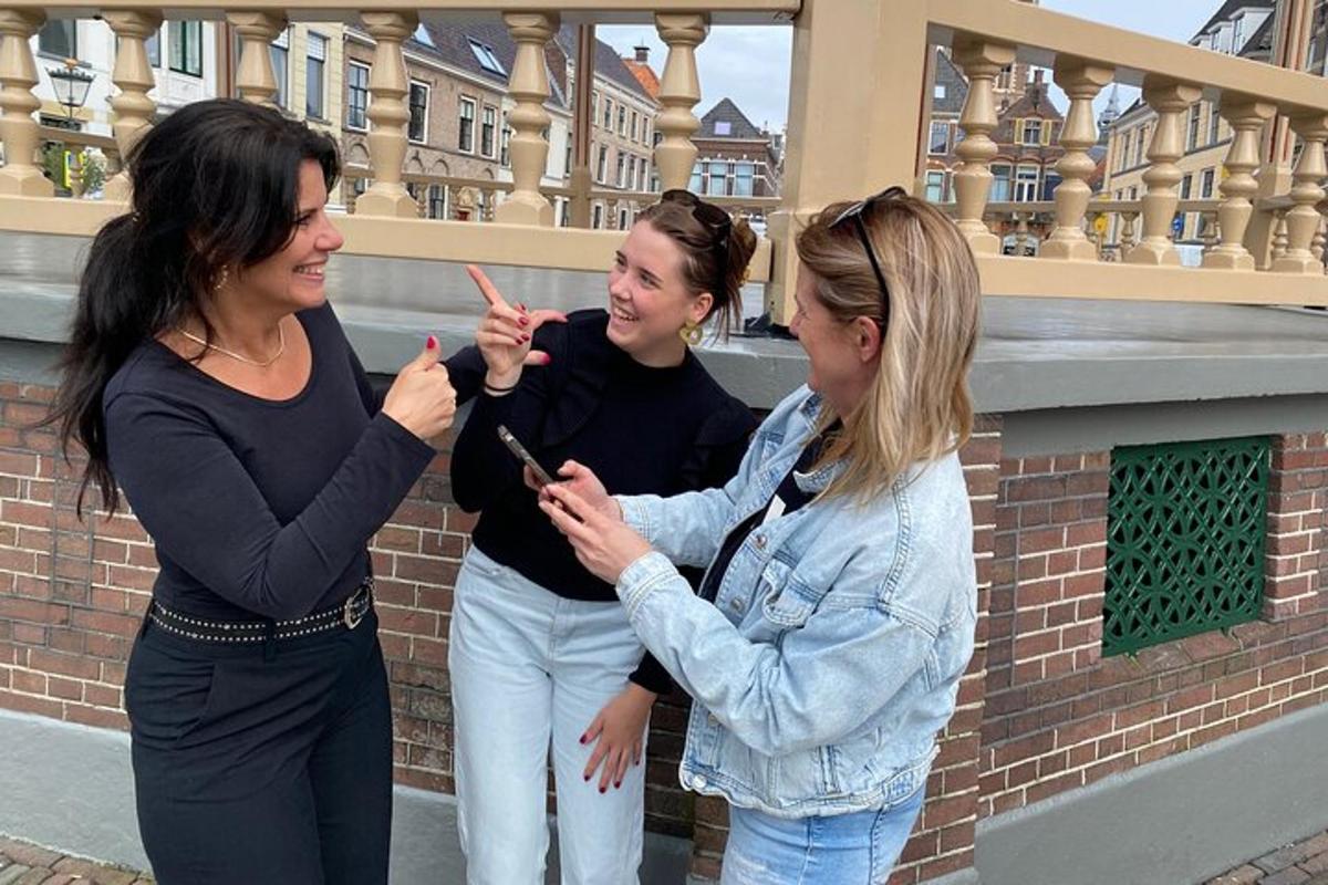 three women standing next to each other looking at a cell phone