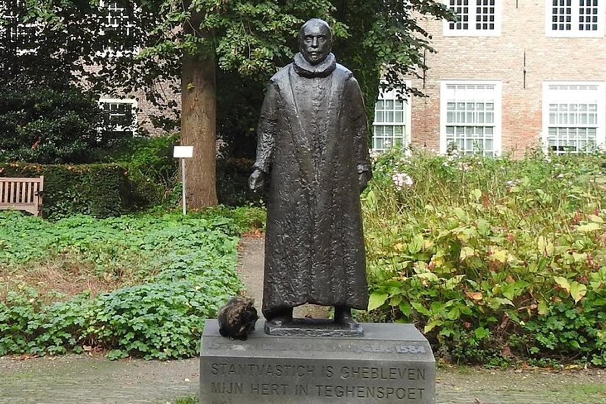 una estàtua d'un home amb un gat assegut al costat
