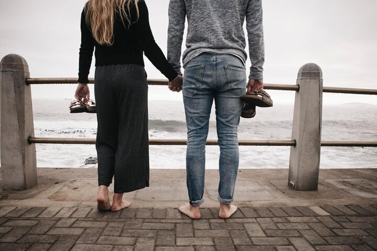 een man en een vrouw staan naast de oceaan