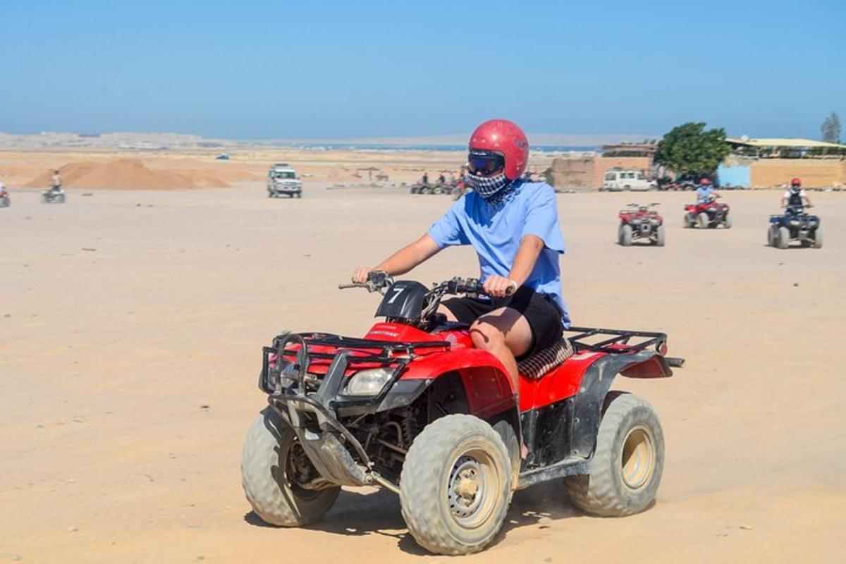 una persona in sella a un quad sulla spiaggia