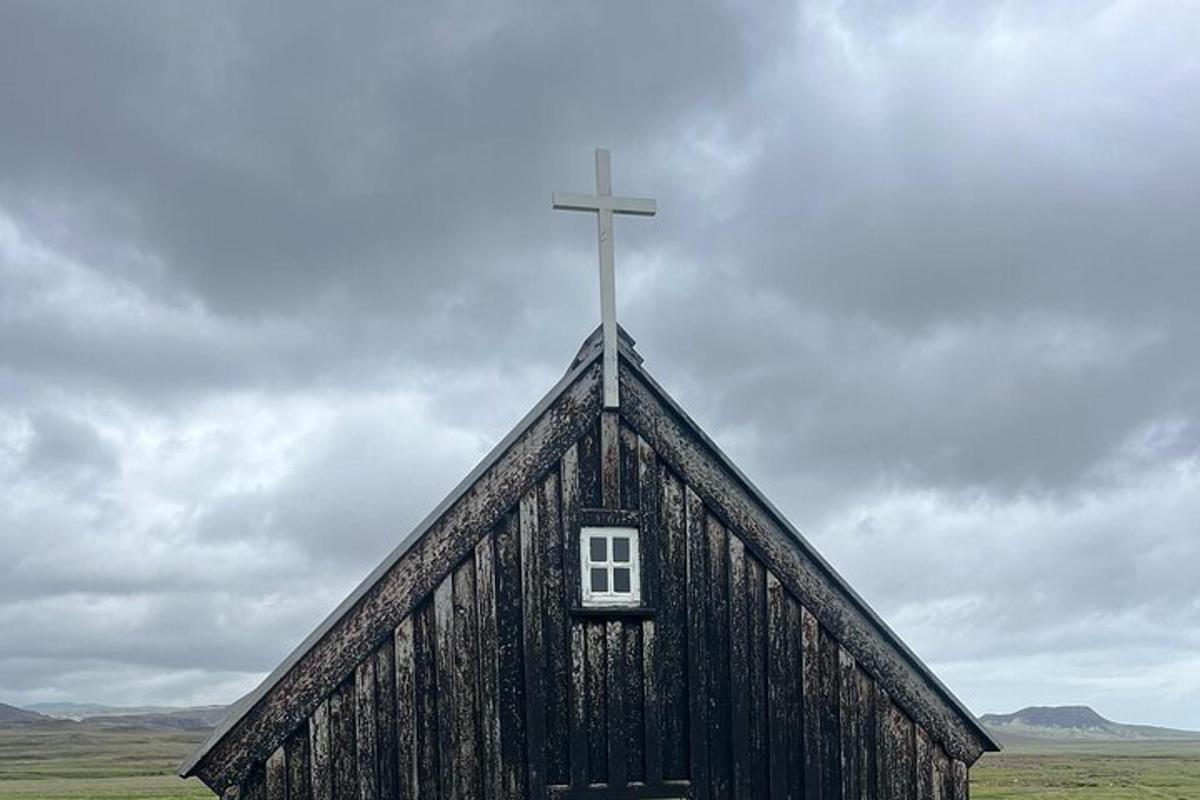 kross á þaki svartrar kirkju