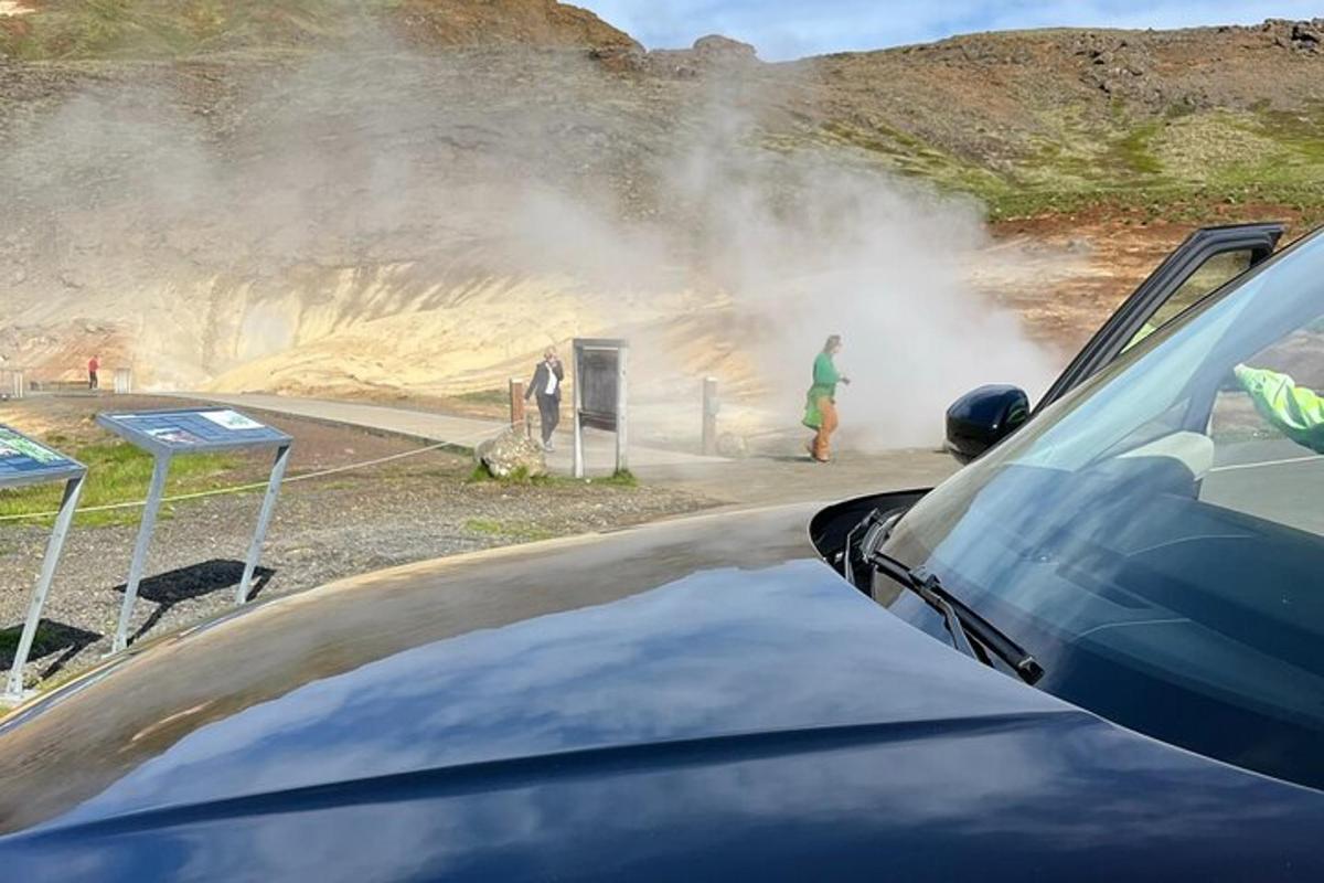 maður stendur við hver nálægt bíl