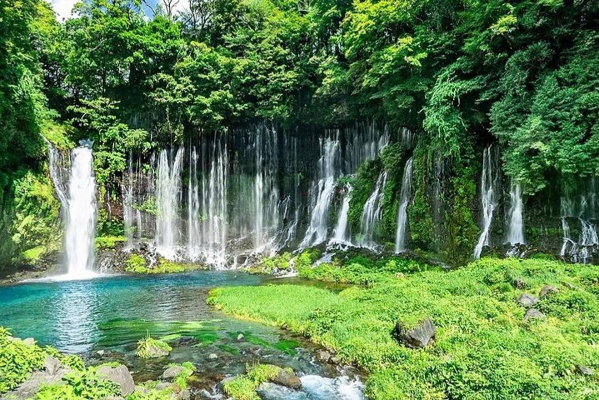 una pozza d'acqua di fronte a una cascata