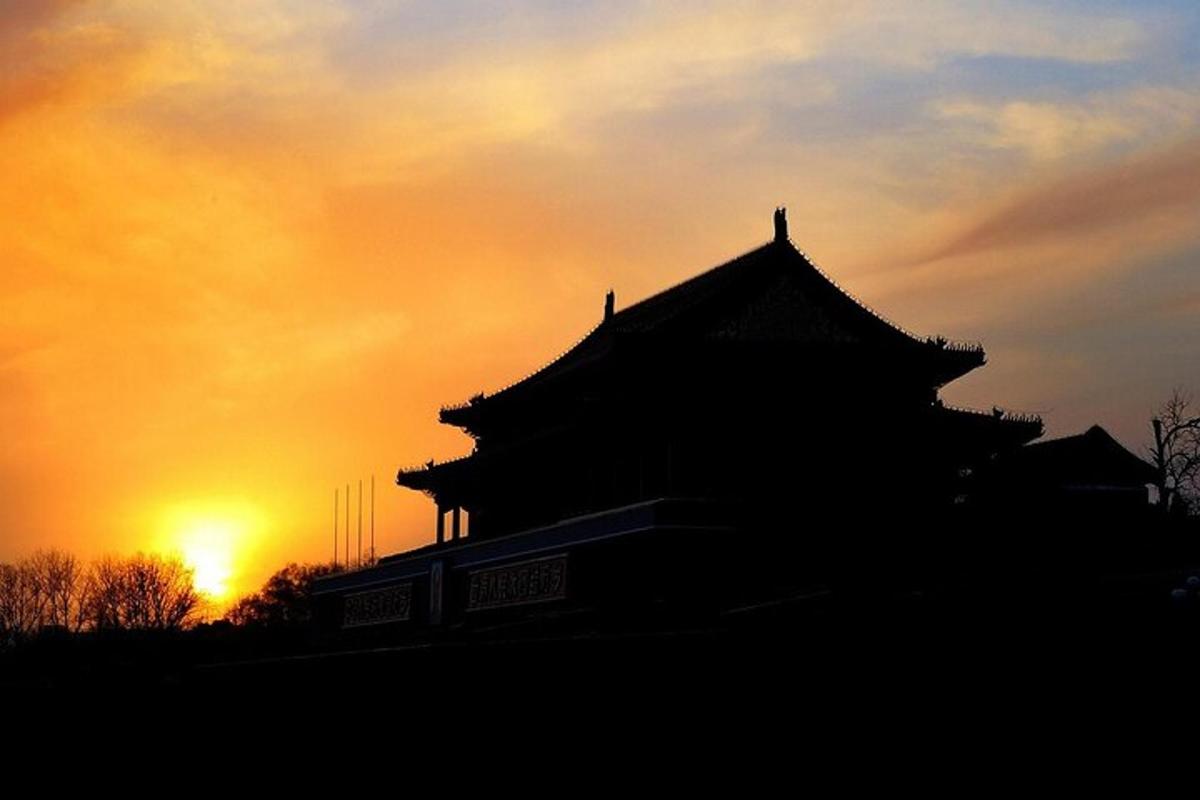 a silhouette of a building with the sunset in the background