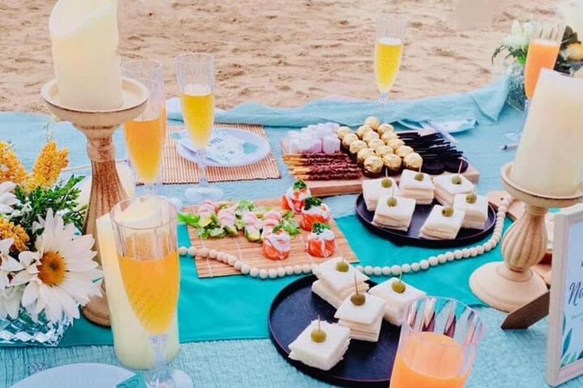 isang asul na mesa na may mga pagkain at inumin sa isang beach