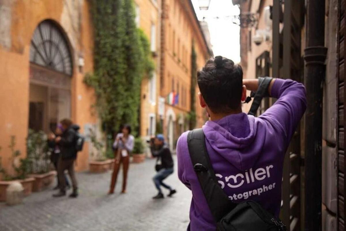 una persona in piedi su una strada che scatta foto di persone