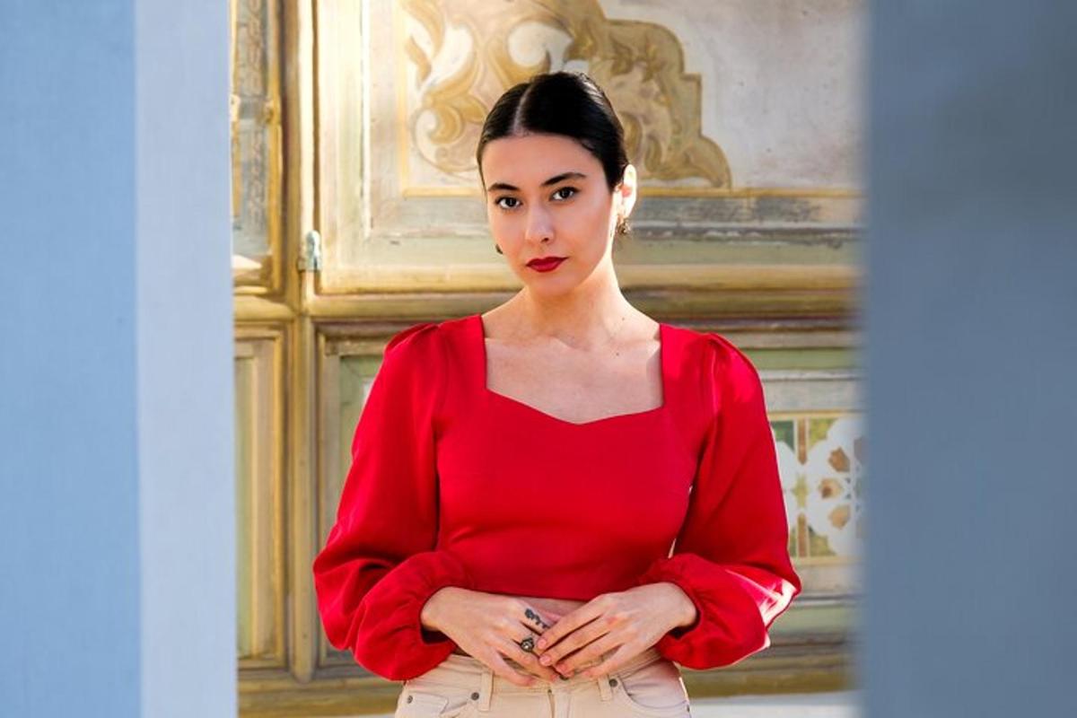 a woman in a red shirt with her arms crossed