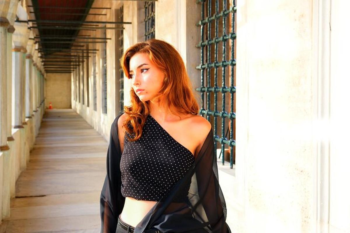 a woman with red hair walking down a hallway