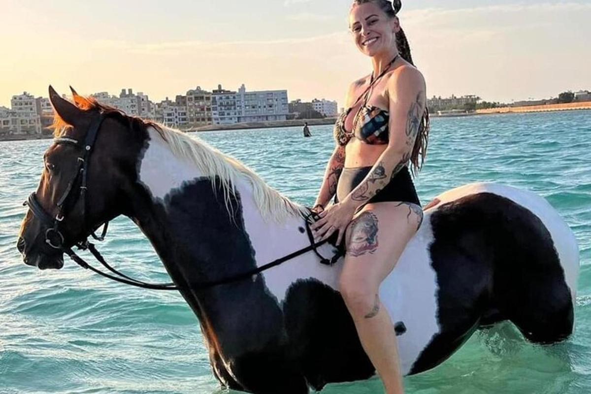sieviete bikini jāj ar zirgu ūdenī