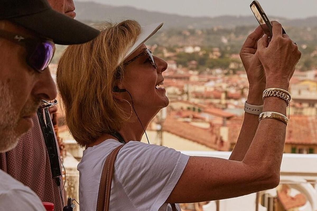 ženska, ki fotografira mesto s svojim mobilnim telefonom