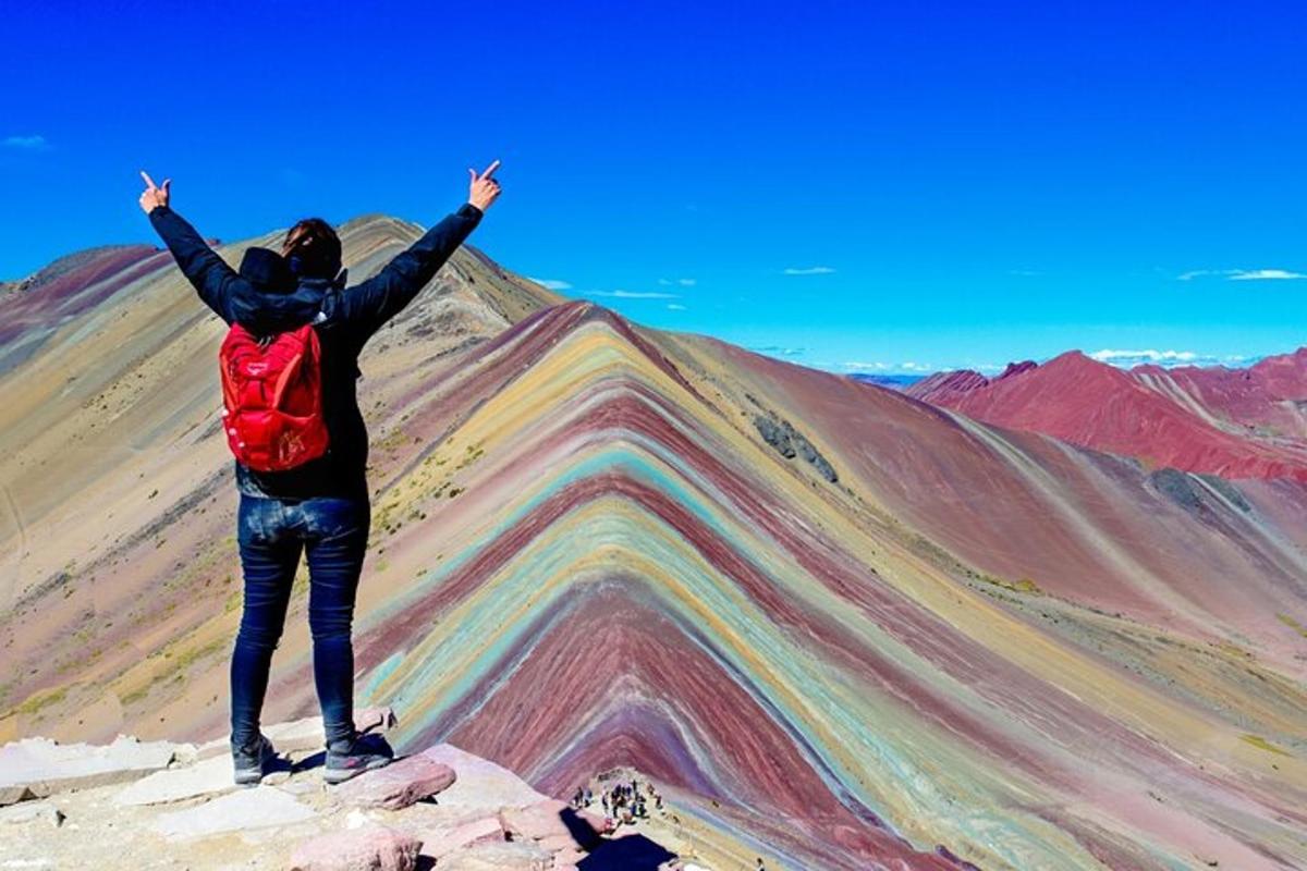 a person standing on top of a mountain with their arms up