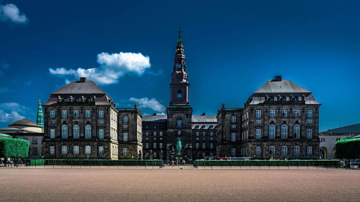 un grande edificio con una torre dell'orologio di fronte