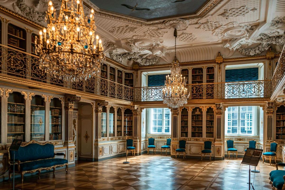 una grande stanza con lampadari e librerie