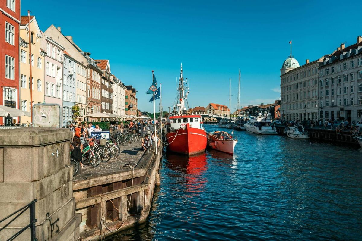 a red boat is docked in a canal with buildings