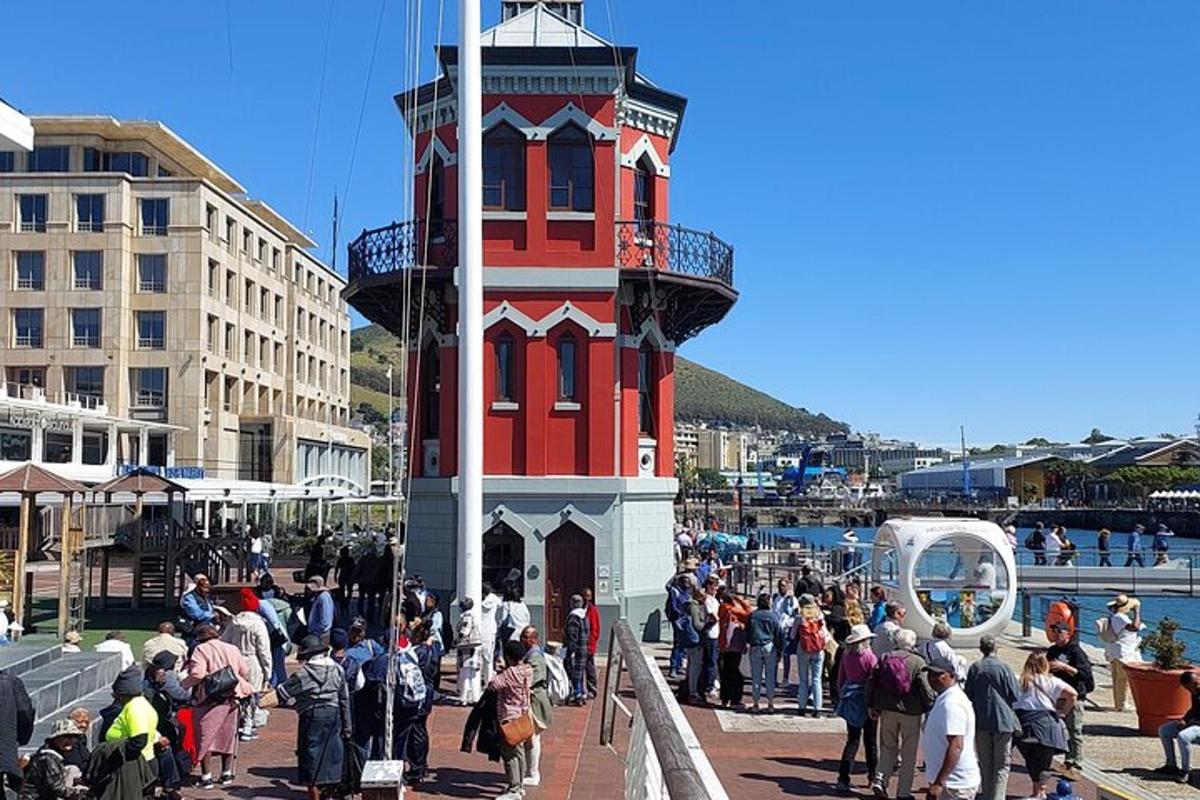 Un grupo de personas de pie alrededor de una torre roja y blanca.