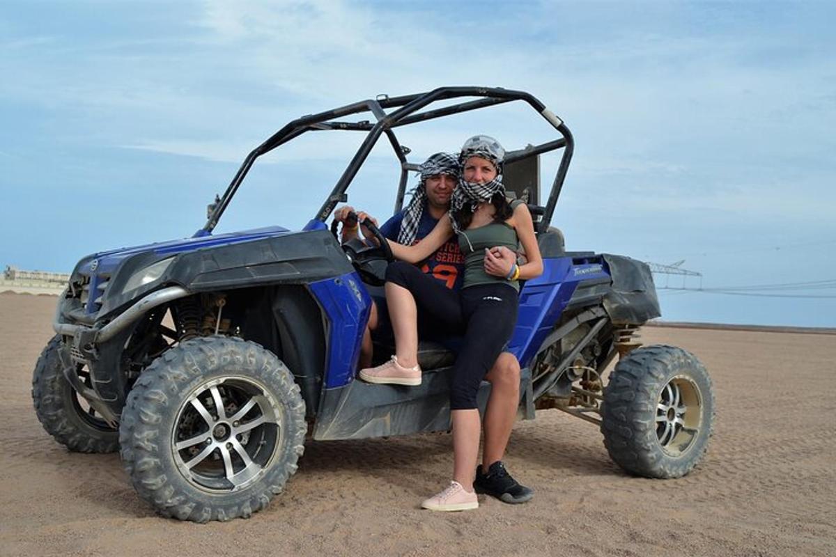 two people sitting in a jeep on the beach