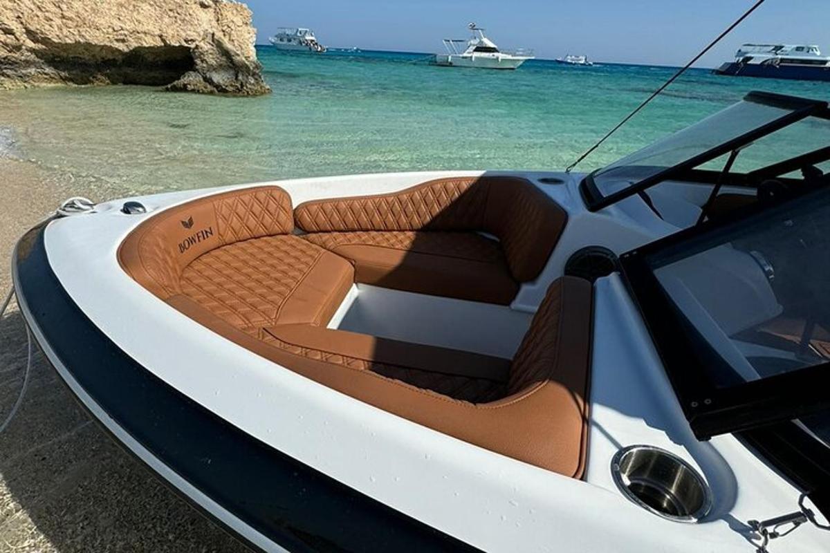 un vaixell blanc assegut a la platja vora l'aigua