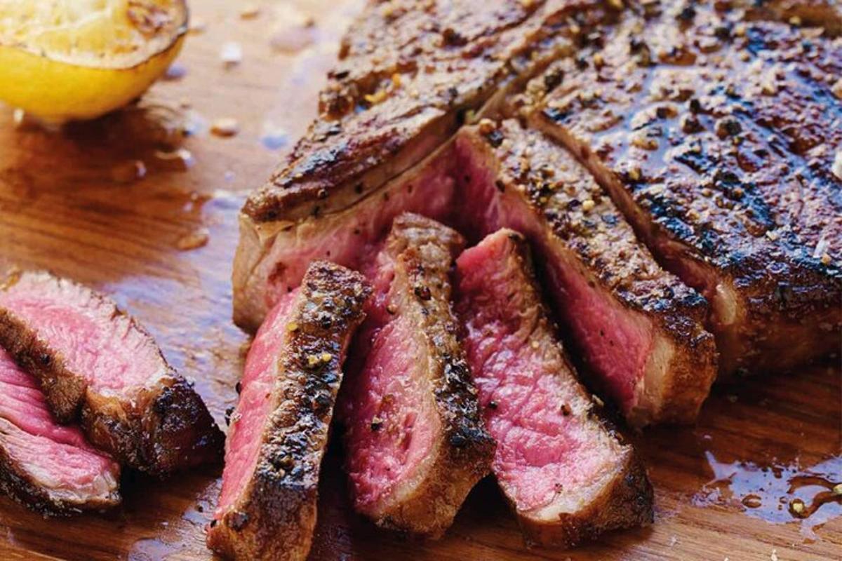 肉とパンが載った木製のまな板