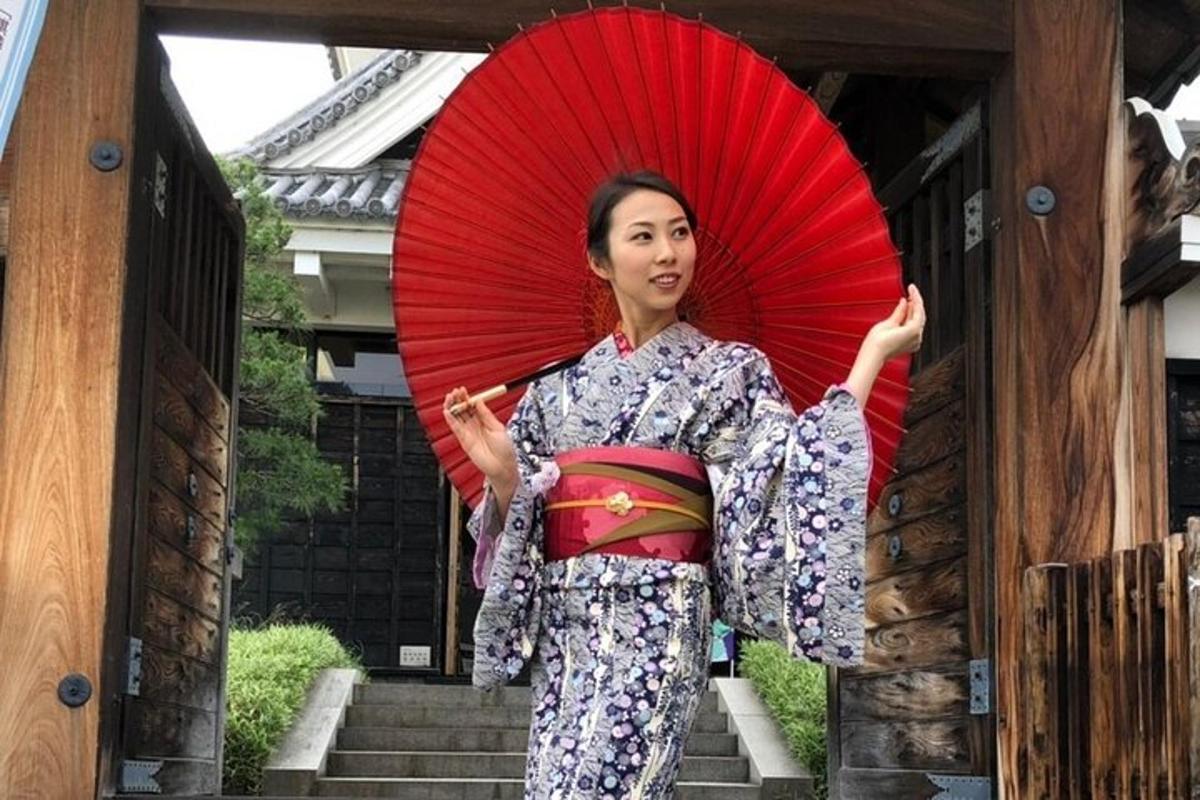 una donna in kimono che tiene in mano un ombrello rosso