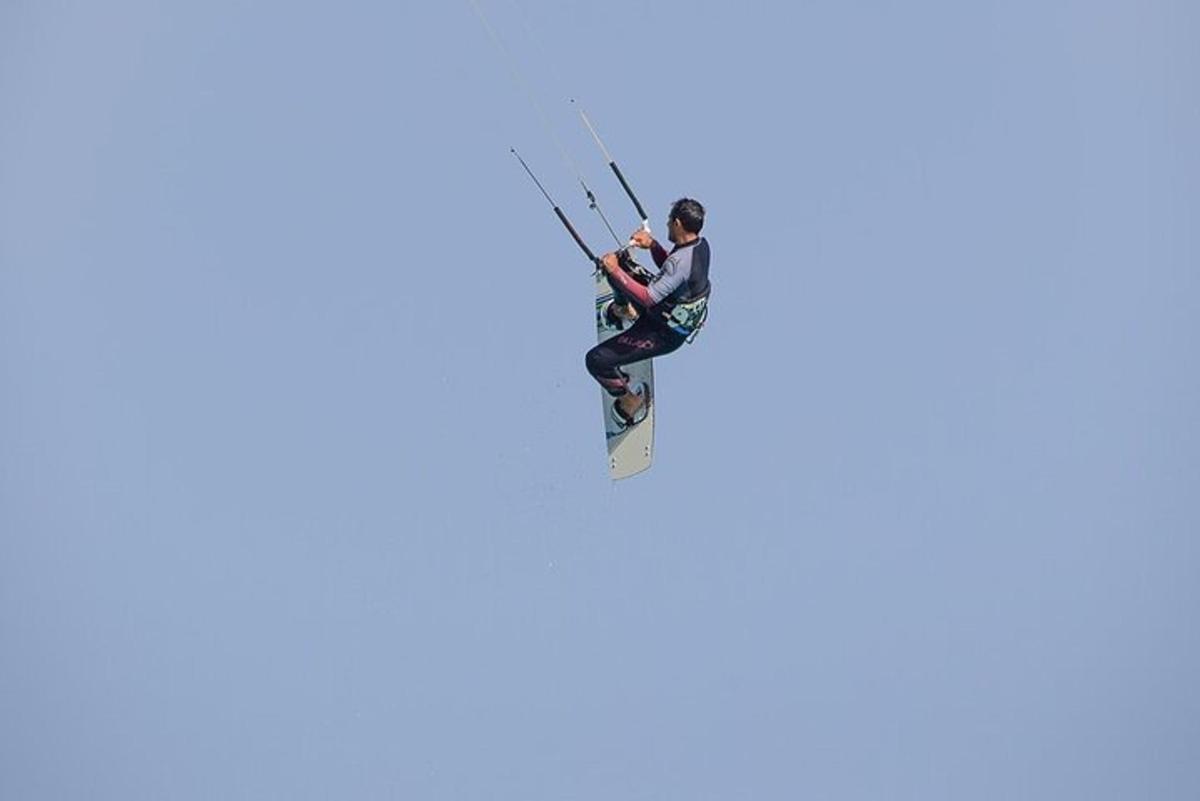 muž kitesurfuje na surfovém prkně