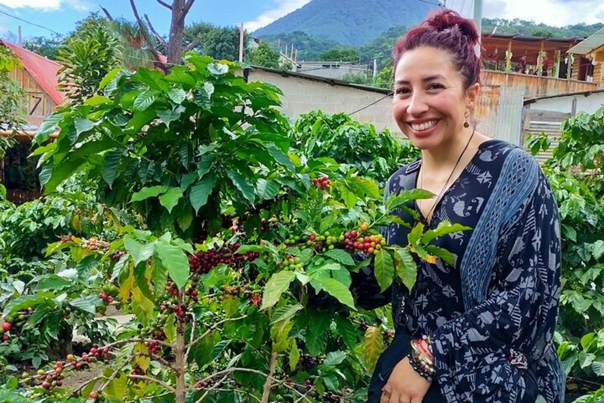 a woman is standing next to a bush ofberries