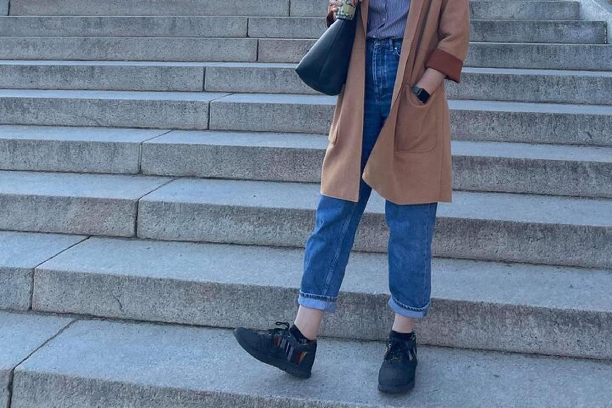 a woman is walking down some stairs in a coat