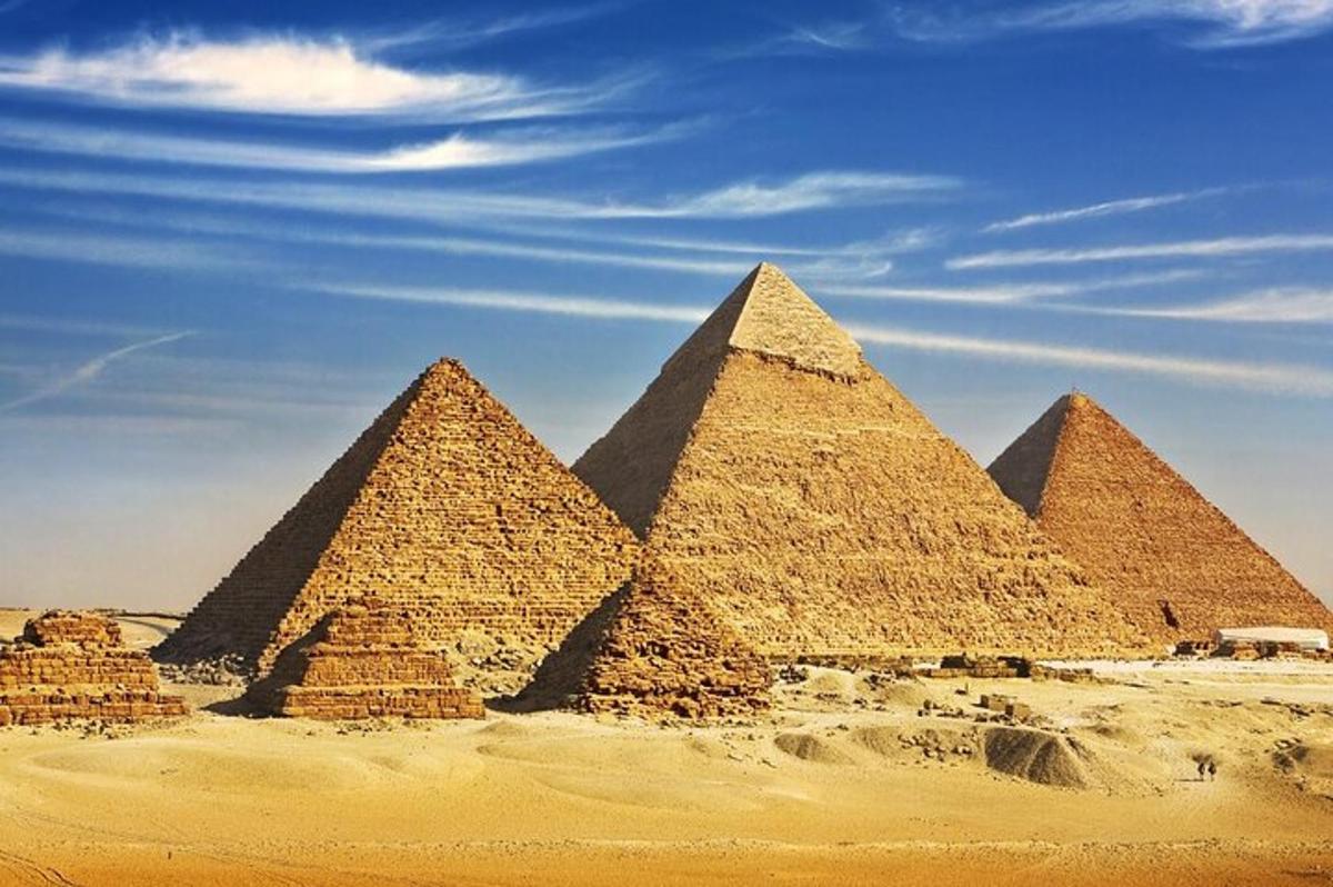 Skupina pyramid v poušti pod modrou oblohou